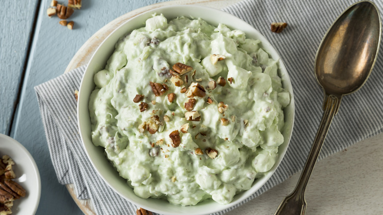 Watergate salad with walnuts in bowl