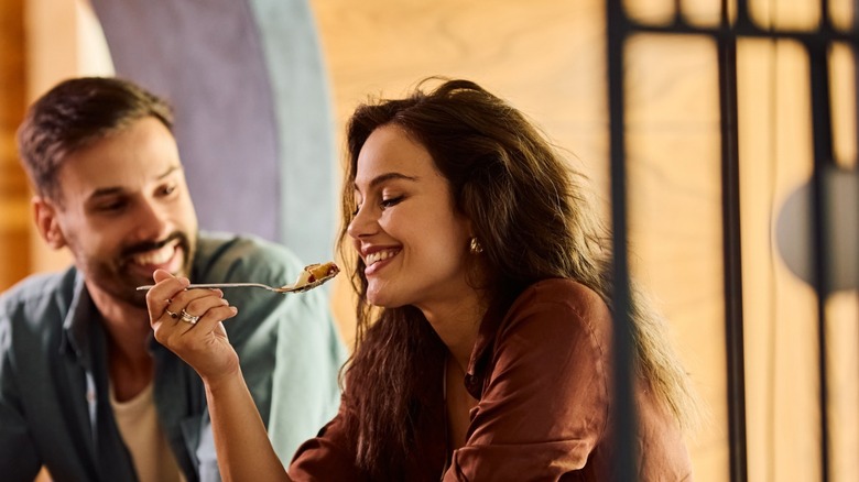 woman eats cake with male companion