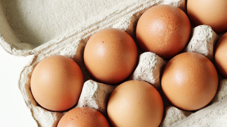 Differently sized eggs in a carton together