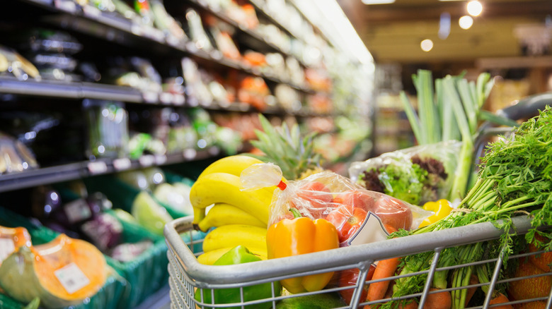 A close-up of a shopping cart full of produce in a grocery store