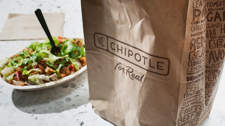 chipotle takeout bag with salad bowl