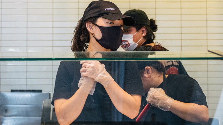 chipotle employees work on the serving line