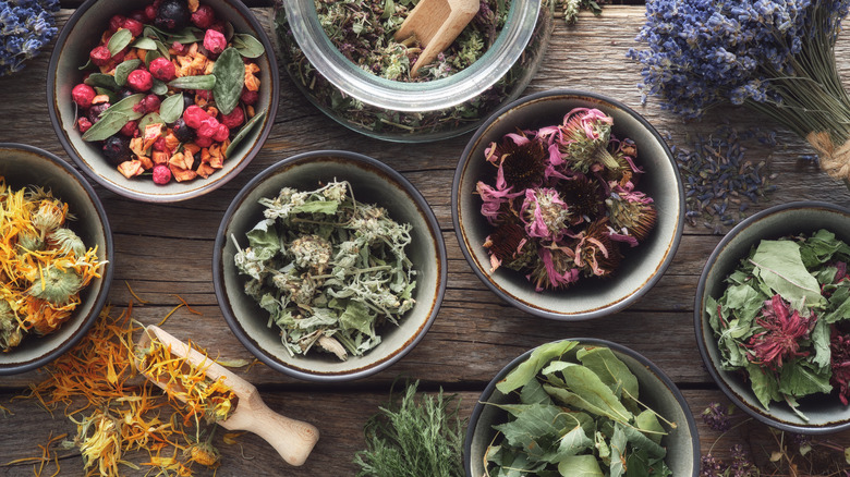 Small bowls of dried flowers, herbs, and seeds. 