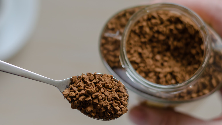 Spoon and jarful of instant coffee crystals