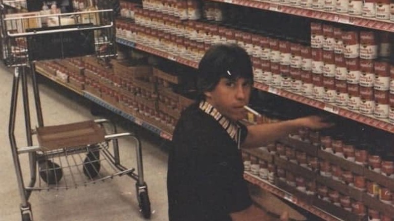 young man smokes cigarette in grocery store