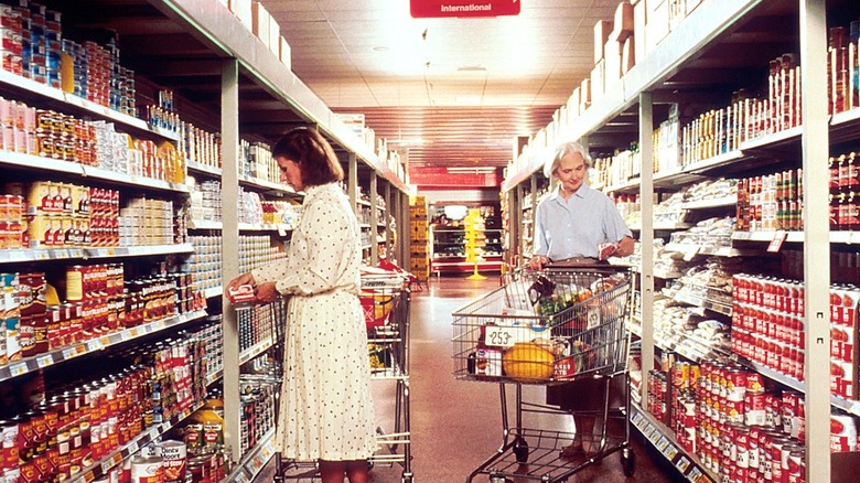 two women in dresses and skirts shop at the grocery store