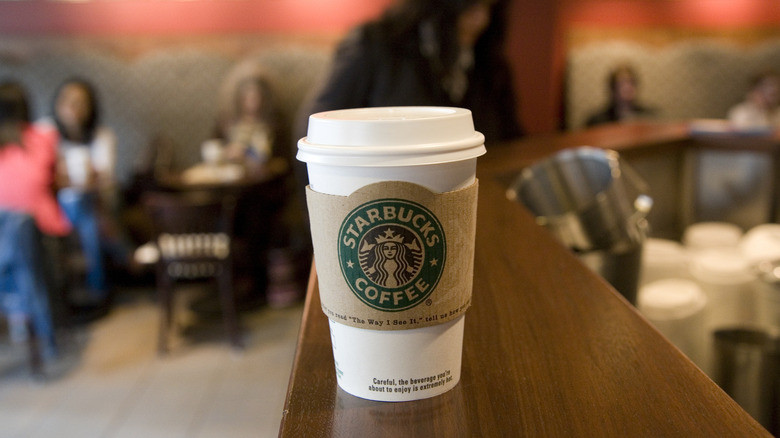 To-go coffee cup on edge of Starbucks counter
