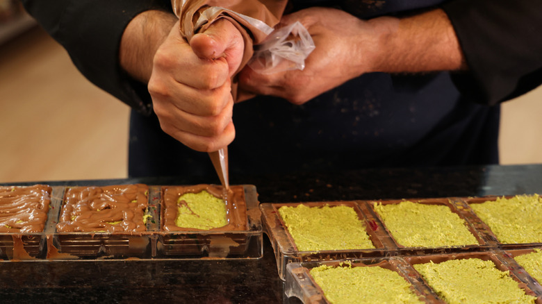 Chef preparing Dubai chocolate in his kitchen.
