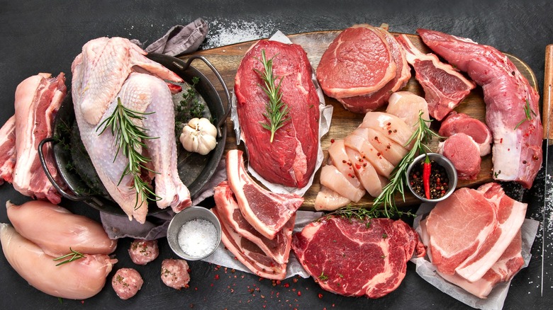 Various raw meats on dark background