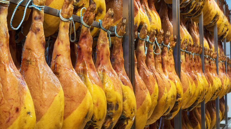 A rack of pork legs curing