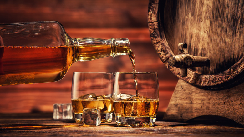 Whisky poured into two glasses next to cask