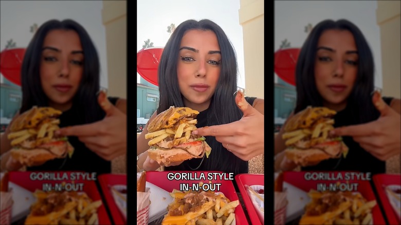 woman holds a sloppy "gorilla style" burger