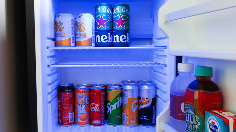 mini fridge full of canned and bottled beverages
