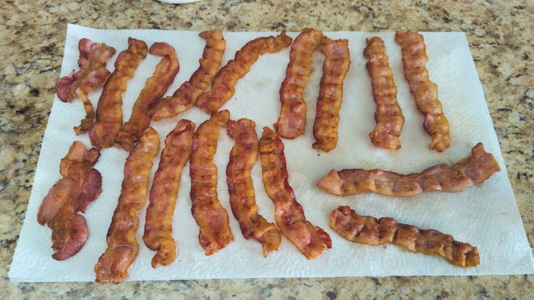 cooked bacon slices drain on paper towels