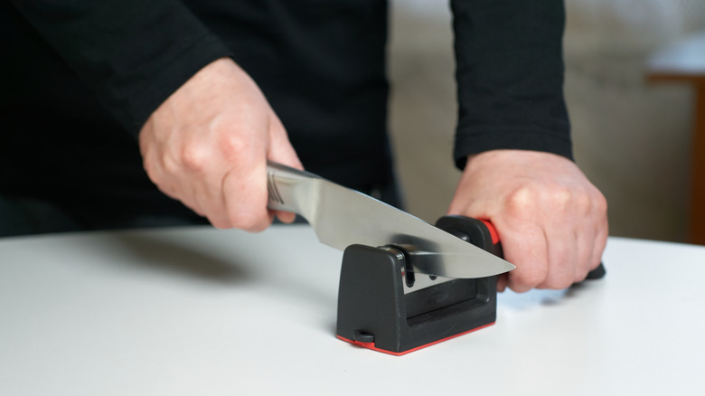 A close-up of someone sharpening a kitchen knife