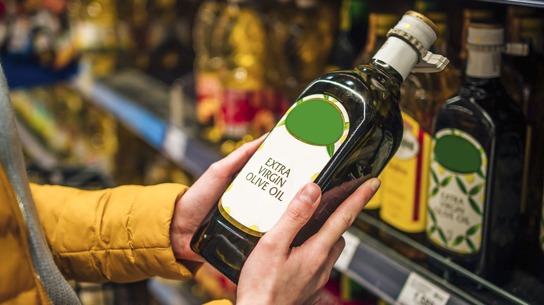 Person buying extra virgin olive oil at the store