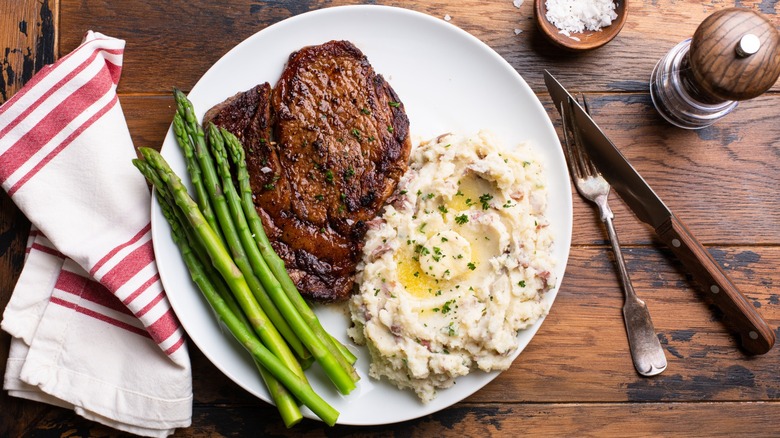 steak dinner with mashed potatoes and asparagus