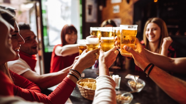 a table full of friends toast with glasses of beer