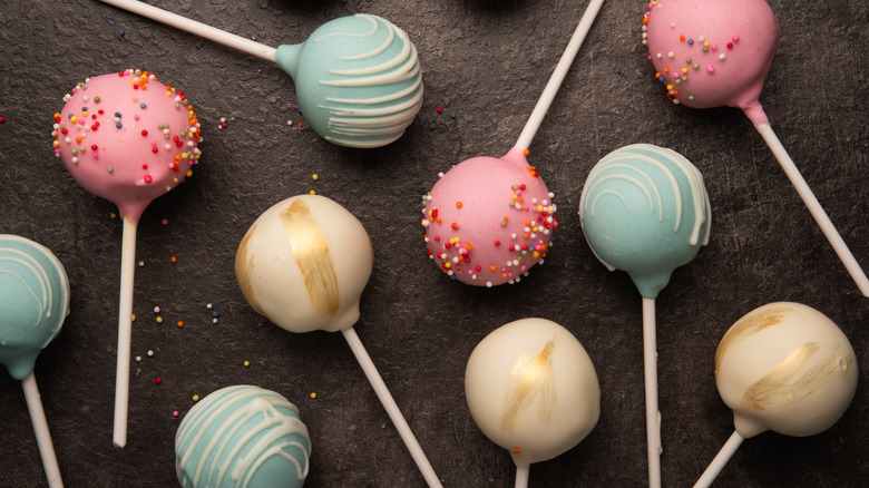 Multicolored cake pops on a black background