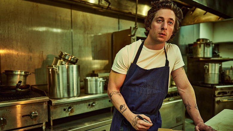 Jeremy Allen White standing in kitchen as Carmen Berzatto in 