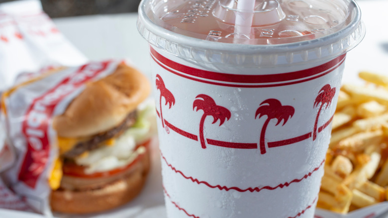closeup of In-N-Out fountain drink with food behind
