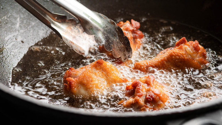 Frying chicken wings in a wok