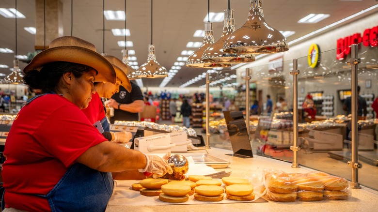 workers in cowboy hats make sandwiches at buc-ee's