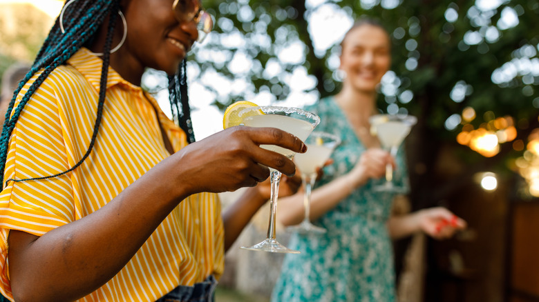 Two women enjoying margarita cocktails outdoors