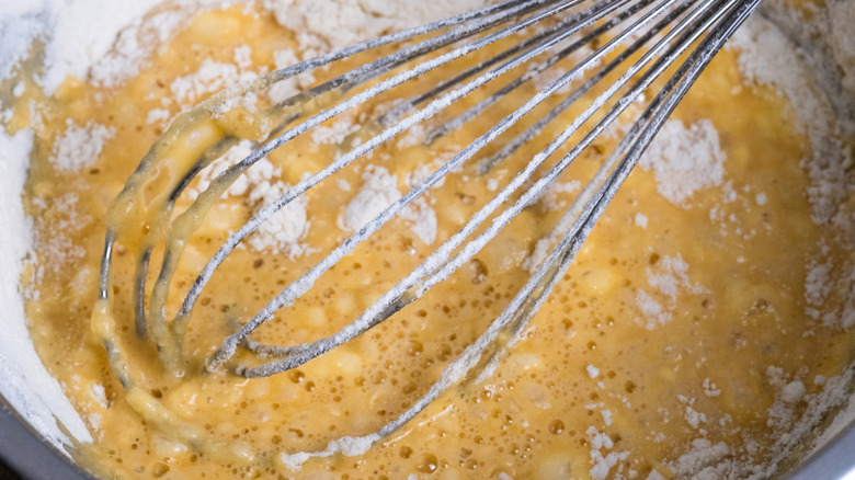Close up of a bowl of batter and whisk
