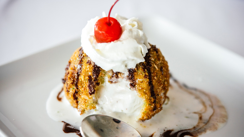 fried ice cream topped with whipped cream and cherry