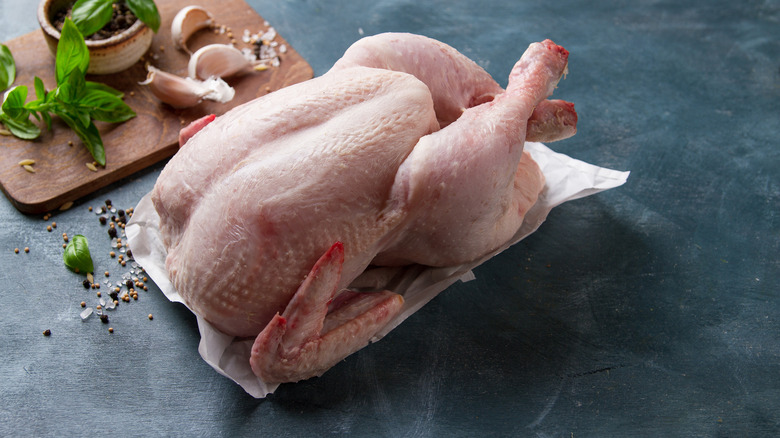 raw whole chicken on parchment paper
