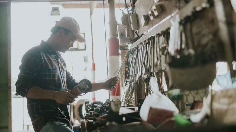 Man looking at tools in home garage, backlit