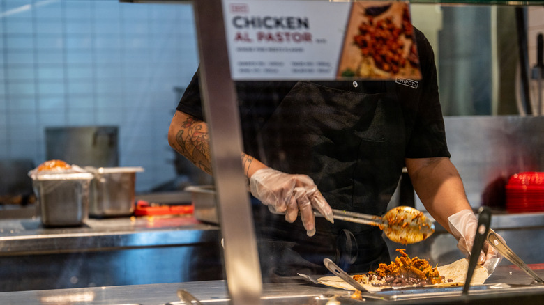 Chipotle employee preparing burrito