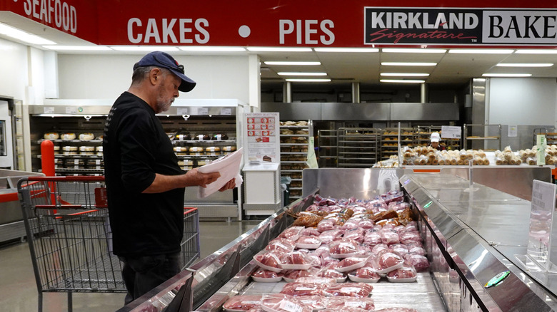 Costco customer looking at packed raw meats.