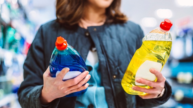 Person looking at two bottles of cleaner in grocery store