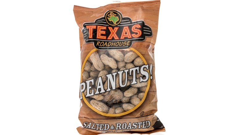Bag of Texas Roadhouse-branded peanuts on white background.