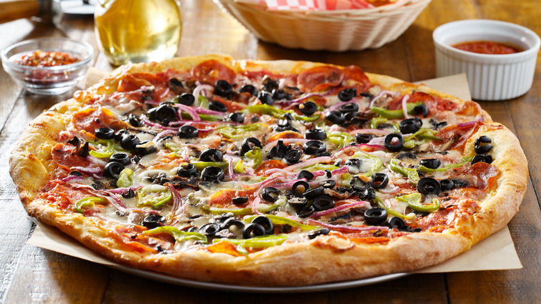 Supreme pizza with olives, pepperoni, and other toppings.
