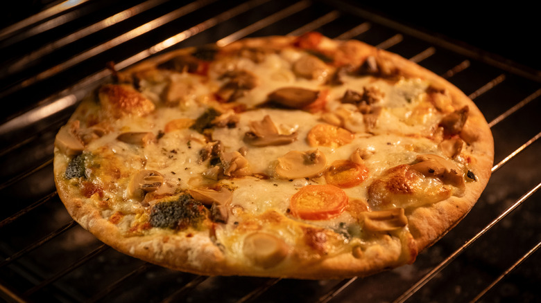 A frozen pizza cooking directly on an oven rack