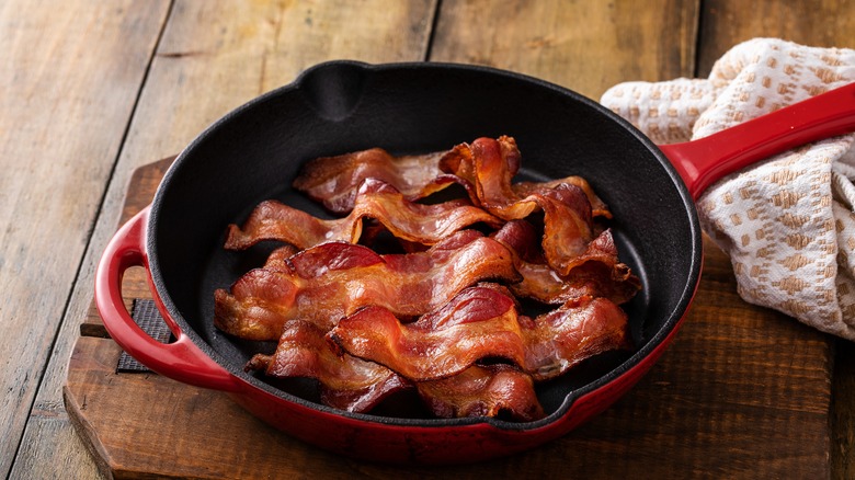 strips of cooked bacon in a cast iron skillet