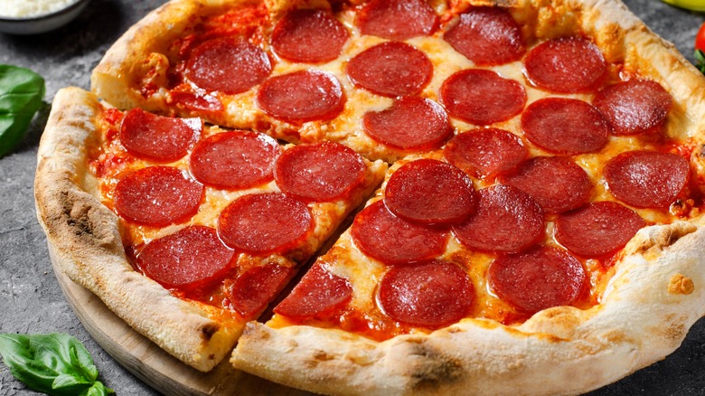 Pepperoni pizza with cut slice close up