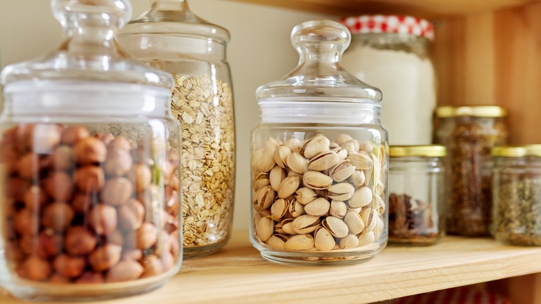 jars filled with nuts on pantry shelf