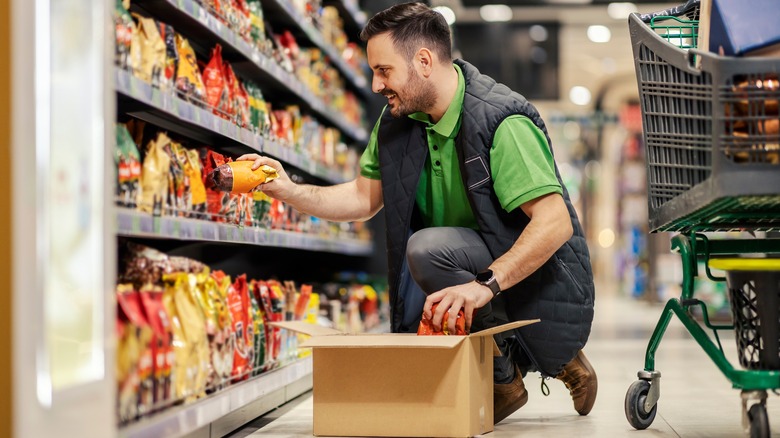 grocery store employee stocking shelves
