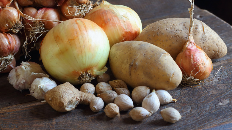 Onions and potatoes on wooden table