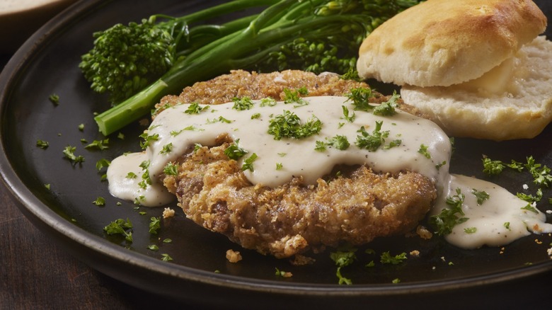 chicken fried steak with broccolini and biscuit