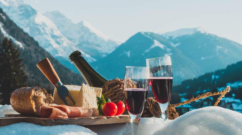 bread and cheese board set against a snowy mountain backdrop