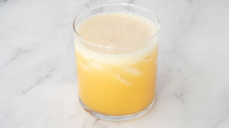 Frothy yellow cocktail in glass