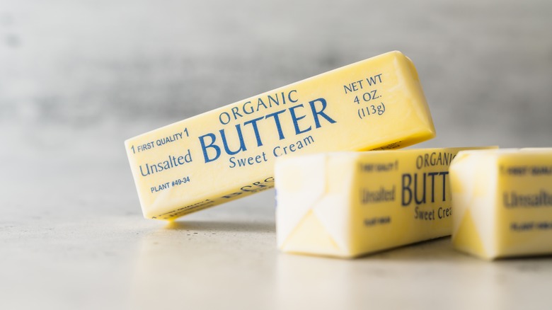 unopened stick of butter resting on other stick of butter
