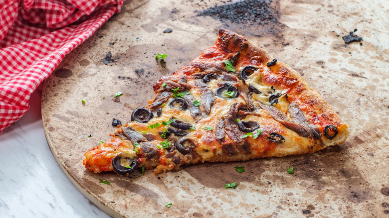 Pizza slice on stained baking stone