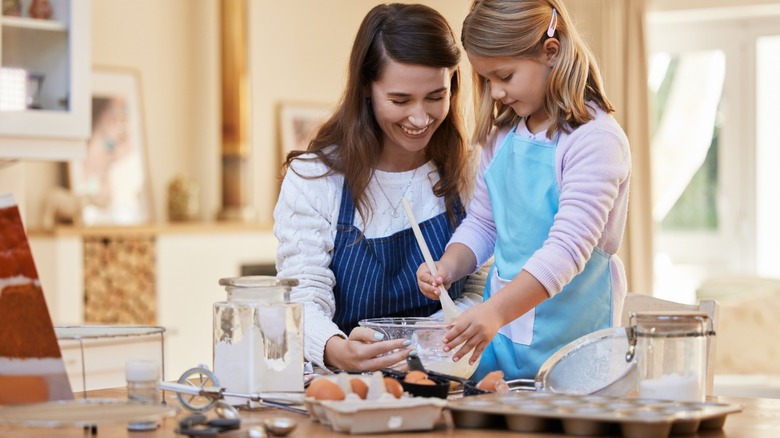 woman and child making a cake in kitchen