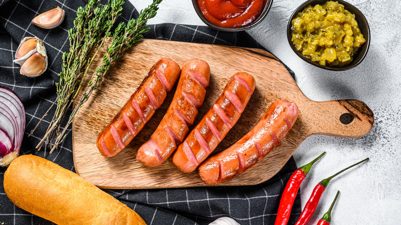 Cooked hot dogs on wood board